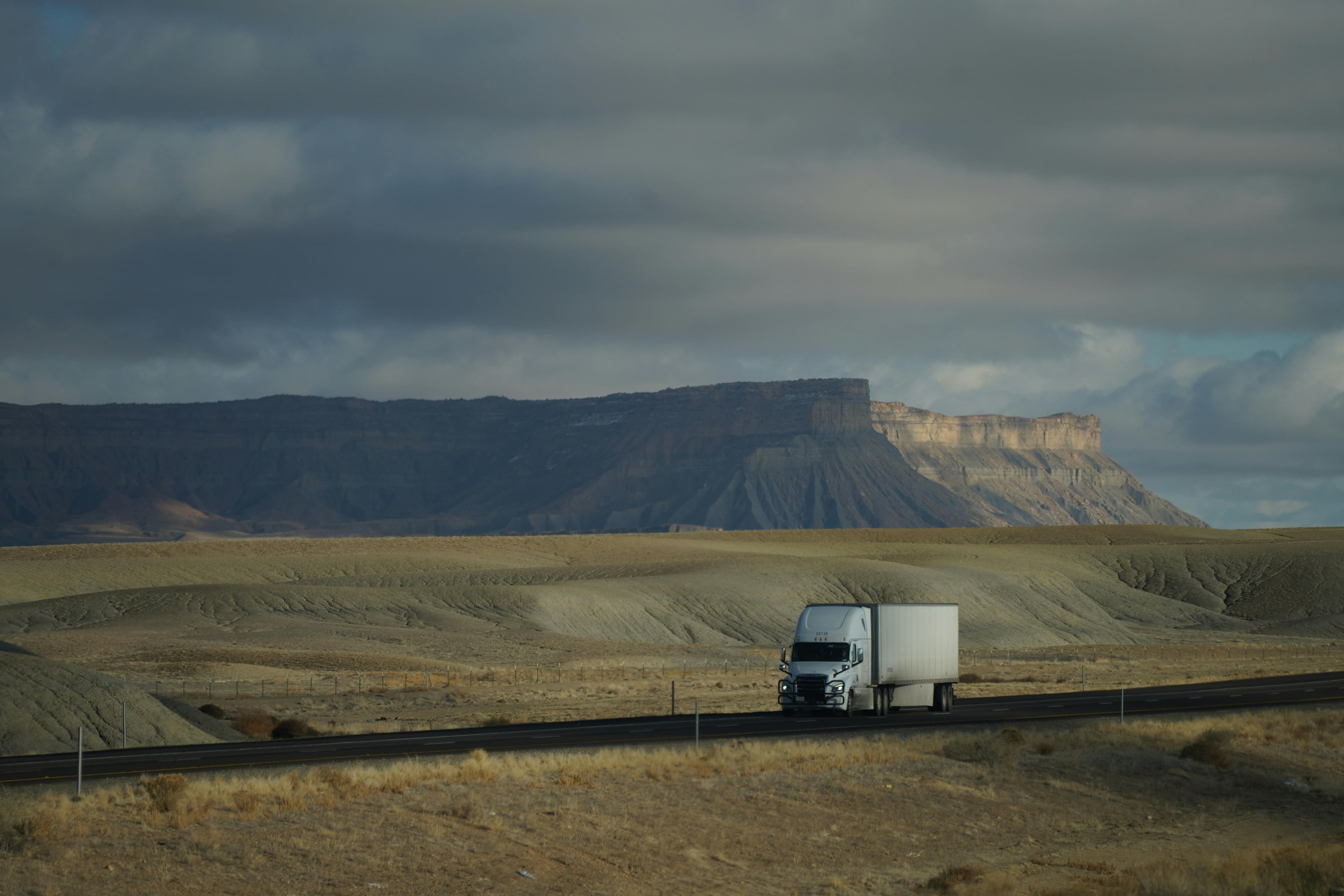 A freight truck traveling through an open desert landscape